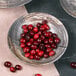 A close-up of a Denali Knotwood melamine bowl filled with cranberries.