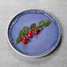 An indigo melamine plate with red berries on it.