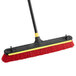 A red and black Quickie Bulldozer squeegee and push broom with a yellow handle.