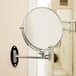 A Conair round wall-mount mirror with chrome.