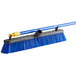 A blue and yellow Quickie Bulldozer rough surface push broom.