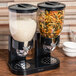 A Zevro black dry food dispenser with rice and noodles in two canisters.