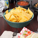 A round polyethylene basket filled with chips on a table.