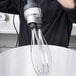 A person using a Waring 10" whisk attachment to mix something.