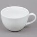 A close-up of a Tuxton bright white round china cup with a handle.