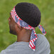 A man wearing an Ergodyne Stars and Stripes evaporative cooling headband with an American flag design.