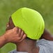 A man wearing a lime green Ergodyne 6630 Skull Cap.
