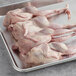 A tray of raw Manchester Farms whole quail with feet.