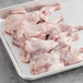 A tray of raw semi boneless quail on a white counter.