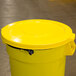A Continental yellow trash can lid on a yellow trash can.