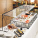 An Aqua Cal-Mil portable sneeze guard over a buffet with a variety of food items.