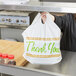 A woman holding a white LK Packaging plastic take out bag with a printed thank you design.