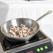 A Vollrath stainless steel fry pan with mushrooms cooking in it.
