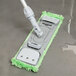 A Unger SmartColor green mop pad with a white handle.