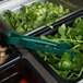 Thunder Group green polycarbonate flat grip tongs being used to serve salad from a salad bar.