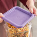 A person using a purple Vigor food storage container with pasta inside and a purple lid.