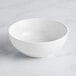 An Acopa Capri coconut white stoneware bowl on a white surface.