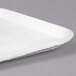 A close up of a white Huhtamaki Chinet molded fiber rectangular tray.