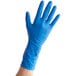 A hand wearing a blue latex glove.