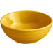 A mango orange Acopa Capri stoneware bowl with yellow food.