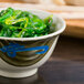 A Thunder Group Wei melamine rice bowl filled with green food.
