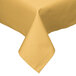 A close up of a yellow Intedge square tablecloth with a folded edge on a table.