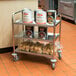 A Choice stainless steel utility cart with food on it.