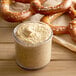 A pretzel with a jar of Regal Yellow Mustard.