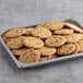 A baking tray filled with JOY chocolate chip cookies.