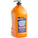 A bottle of orange Dial heavy-duty liquid hand soap with a pump.