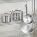 A stainless steel rack with Vigor SS1 Series stainless steel pots and pans on it.