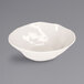A Cal-Mil ivory melamine bowl on a gray surface.