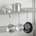 A metal rack with Choice aluminum pots and pans on it.