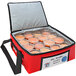 A red Sterno delivery bag cooler with a plastic container of food inside.