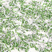 A pile of green and white confetti on a white surface.