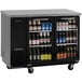 A Turbo Air Super Deluxe narrow back bar cooler with glass doors filled with bottles of beer.
