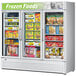 A Turbo Air white glass door freezer with frozen foods inside and an LED sign that says frozen foods.