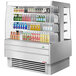 A Turbo Air stainless steel square island display case filled with refrigerated drinks.
