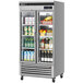 A Turbo Air reach-in refrigerator with glass doors full of drinks.