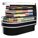 A Turbo Air stainless steel oval island display case filled with drinks on shelves.