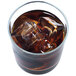 A glass of brown liquid with Manitowoc regular size ice cubes in it.