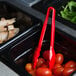 A black container with a red Cambro Lugano tongs in it.