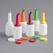 A group of Choice plastic pour bottles with assorted colored caps.