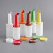 A group of six Choice plastic pour bottles with assorted colored necks and caps.