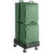 A stack of green plastic containers on a cart with a green CaterGator cooler strap on top.