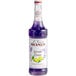A bottle of Monin lavender lemon flavoring syrup with purple liquid.