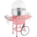 A pink Carnival King cotton candy machine on a pink cart with black wheels and a stainless steel bowl.