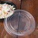 A bowl of coleslaw with a Solo plastic lid on a table in a salad bar.