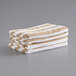 A stack of Monarch Brands Cali Cabana pool towels in white and tan stripes on a gray surface.
