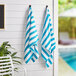 Two Monarch Brands blue and white striped towels hanging on a wall.